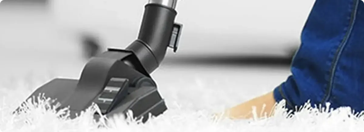 Close-up of a professional vacuuming a white carpet in South San Francisco.